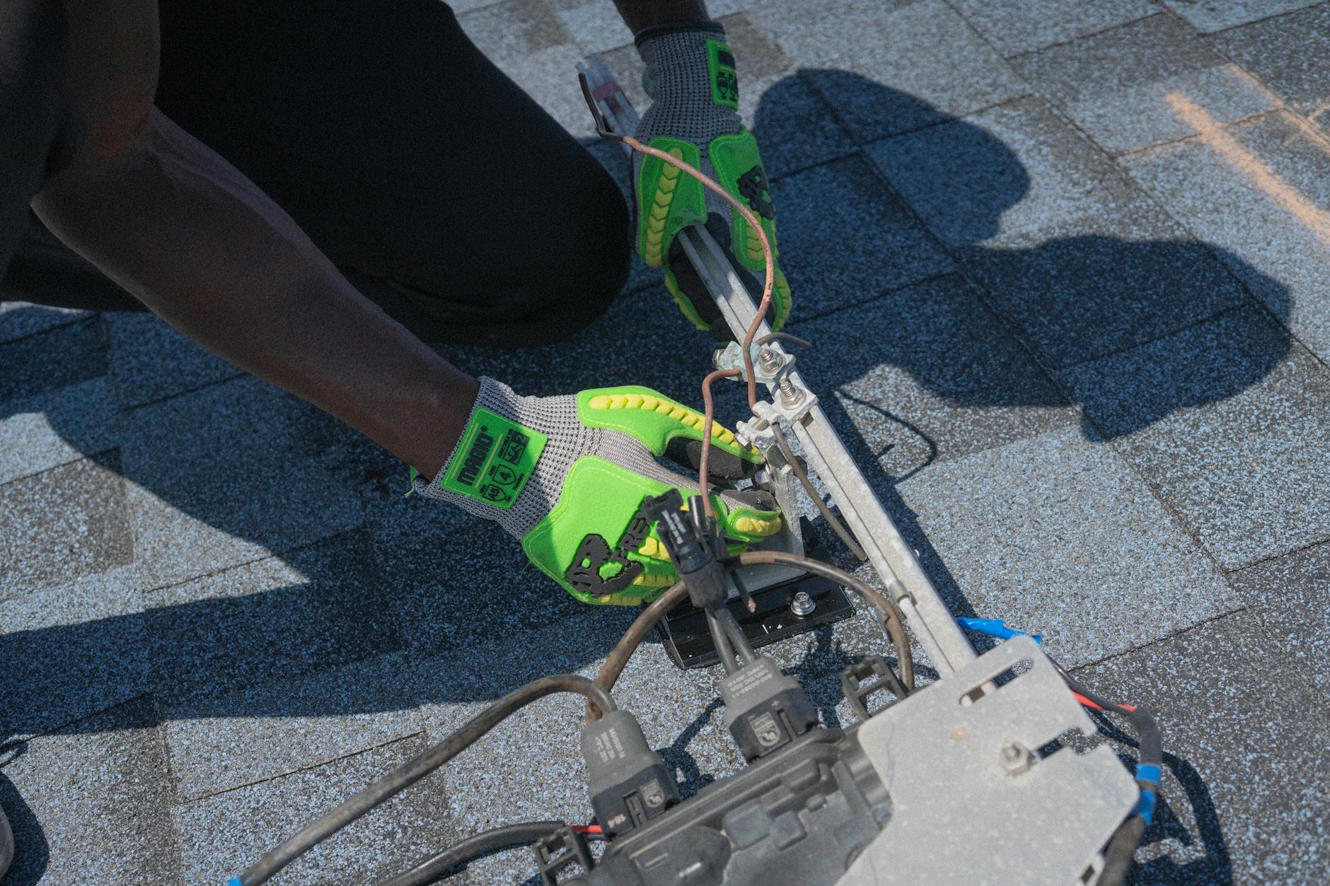 A roofing professional inspecting a residential roof edge near the Wasatch foothills in North Salt Lake.